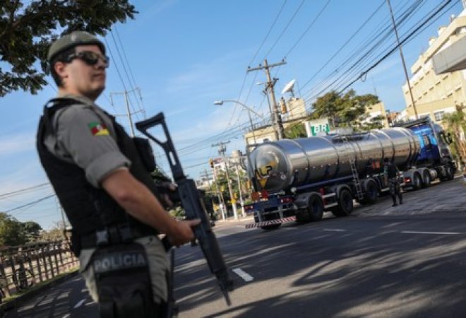 Policial se posiciona enquanto caminhão chega para abastecer posto de combustível em Porto Alegre