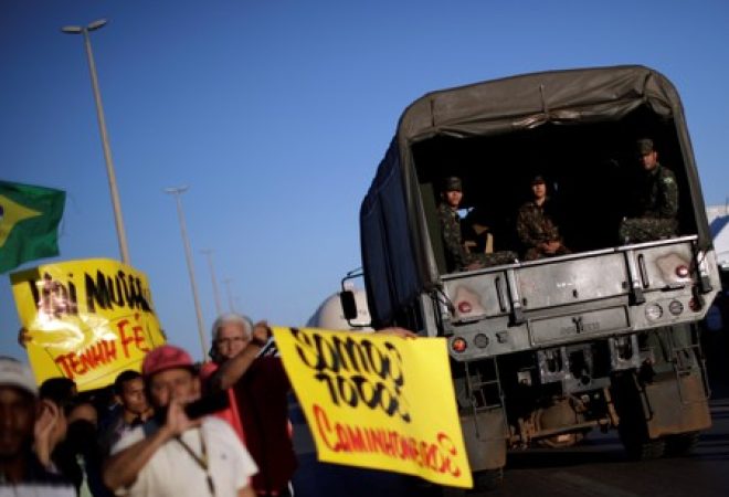 Caminhão do Exército passa por pessoas apoiando caminhoneiros em greve em Luziânia, no Brasil