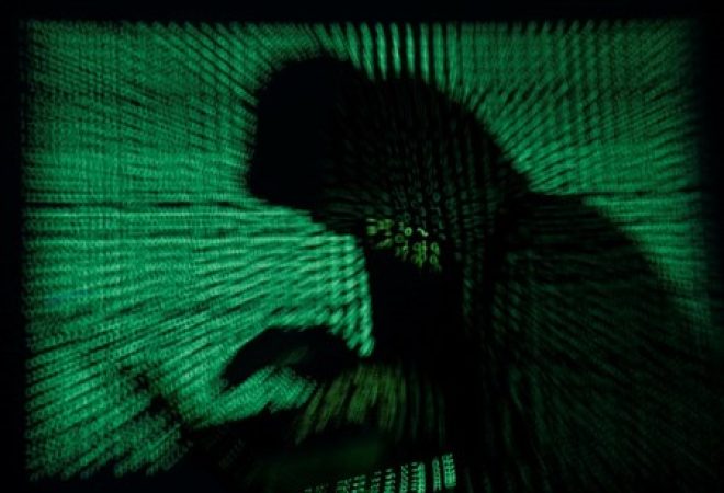 Encapuzado segura um laptop enquanto um código cibernético é projetado