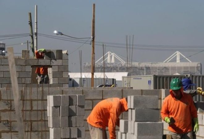Homens trabalham na construção de casas no Rio de Janeiro