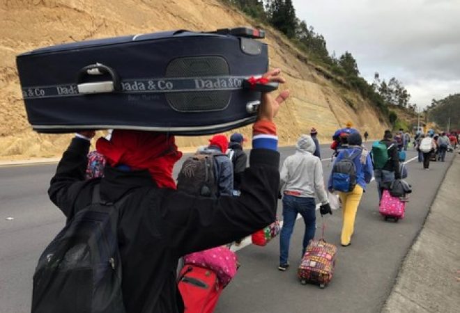 Venezuelanos caminham por estrada equatoriana a caminho do Peru em Tulcán