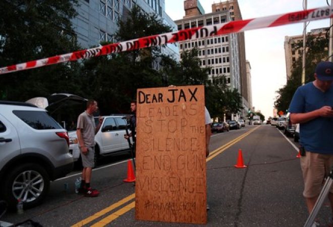 Homem segura cartaz em apoio a controle de armas em Jacksonville