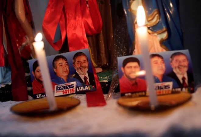 Maria Rosalina da Silva reza com material antigo de campanha do ex-presidente Luiz Inácio Lula da Silva em Caetes, Pernambuco