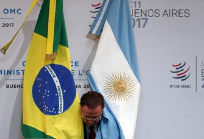 Homem posiciona bandeiras do Brasil e da Argentina em Buenosn Aires, Argentina
