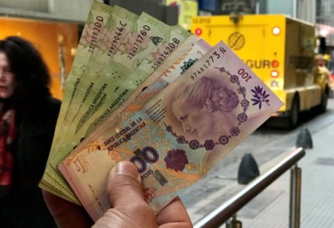 Pessoa segura notas de peso argentino em Buenos Aires, Argentina