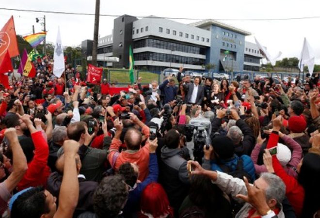 Workers Party Presidential candidate Fernando Haddad, gestures to his supporters in front of the Federal Police headquarters, where Brazilian former President Luiz Inacio Lula da Silva is imprisoned, in Curitiba