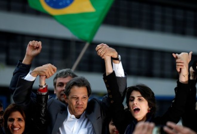 Candidato do PT à Presidência, Fernando Haddad, dá as mãos com candidata a vice, Manuela D'Ávila em frente à sede da Polícia Federal em Curitiba