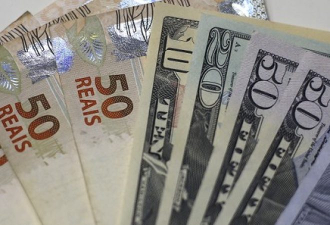 Notas de reais e dólares em foto ilustrativa