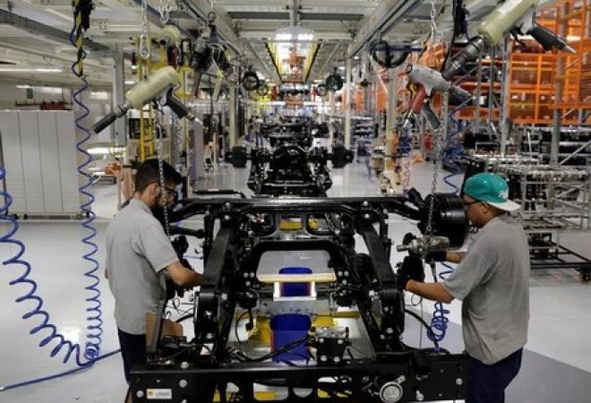 Trabalhadores em linha de montagem de fabrica de caminhões em São Bernardo do Campo