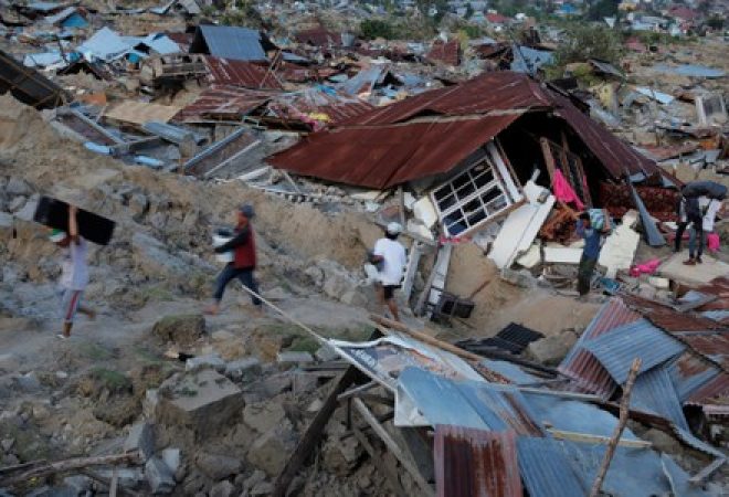 Moradores carregam pertences após terremoto atingir o distrito de Palu, na Indonésia