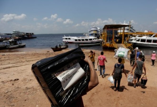 Funcionário da Justiça Eleitoral transporta urna para local de votação no Porto de Manaus