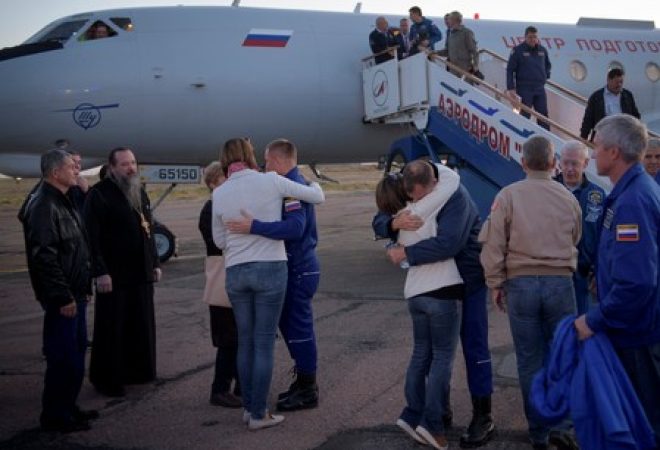 Cosmonauta russo Alexey Ovchinin e astronauta dos EUA Nick Hague abraçam familares após pouso de emergência no Cazaquistão