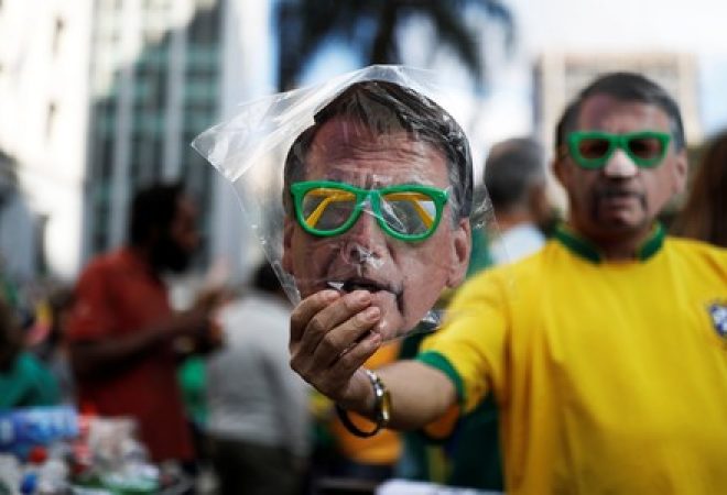 Homem vende máscara de Jair Bolsonaro durante manifestação em apoio ao candidato do PSL à presidência em São Paulo