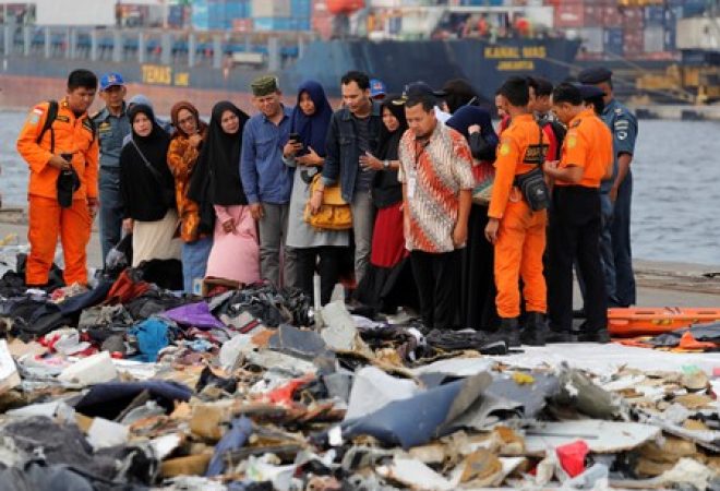 Familiares de passageiros de voo da Lion Air que caiu no mar observam pertences de passageiros do avião no porto de Jacarta
