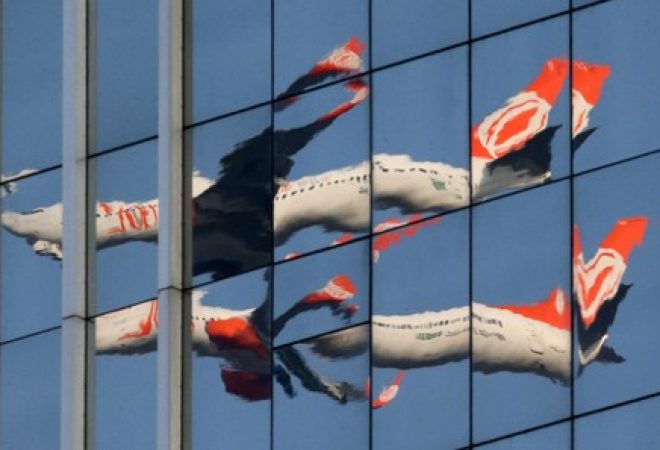 An aircraft of Gol Linhas Aereas Inteligentes SA is seen reflected in a building mirror as it departs from Congonhas airport in Sao Paulo