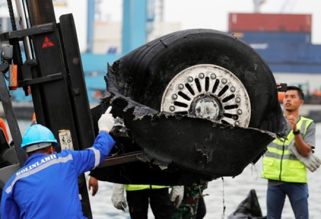 Roda de avião que caiu no mar na Indonésia é transportada por funcionários em porto de Jacarta