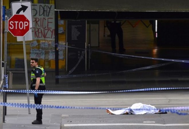 Policial ao lado de corpo coberto no centro de Melbourne