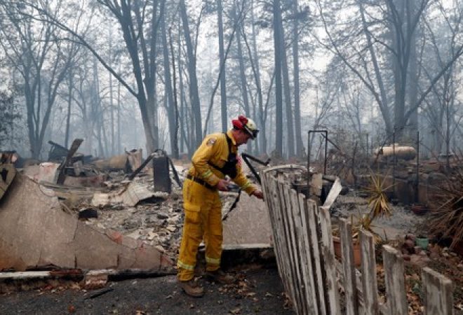 Bombeiro inspeciona casa destruída por incêndio florestal em Paradise, na Califórnia