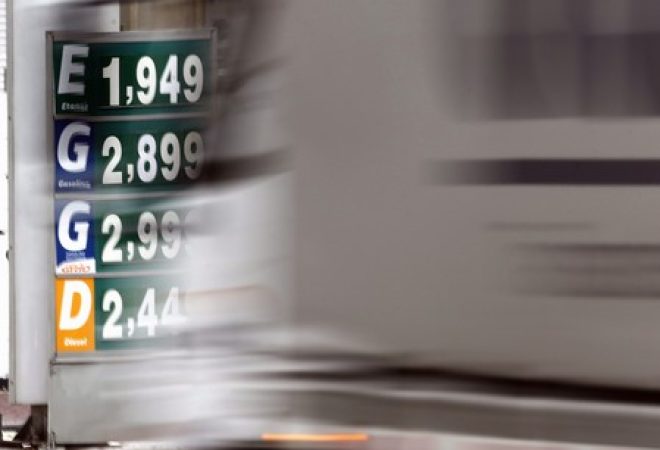 Caminhão passa por placa com preços de combustível em posto de gasolina