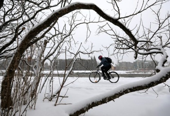Ciclista passa por local tomado pela neve em Ottawa, no Canadá