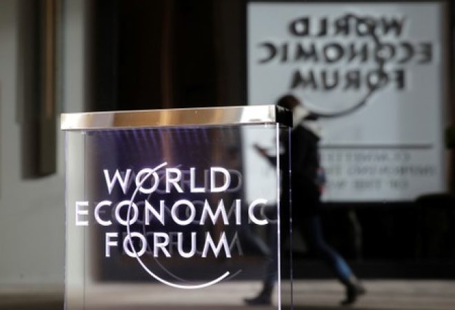 Pessoa passa pelo logo do Fórum Econômico Mundial, em Davos
