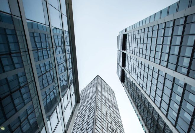 A vertical low angle shot of high rise skyscrapers in a glass facade in Frankfurt, Germany