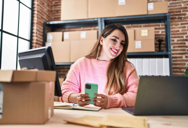 Young beautiful hispanic woman ecommerce business worker using smartphone at office