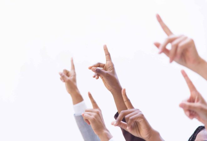 Hands of businesspeople pointing index fingers up. Isolated arms on white background. Training or direction concept
