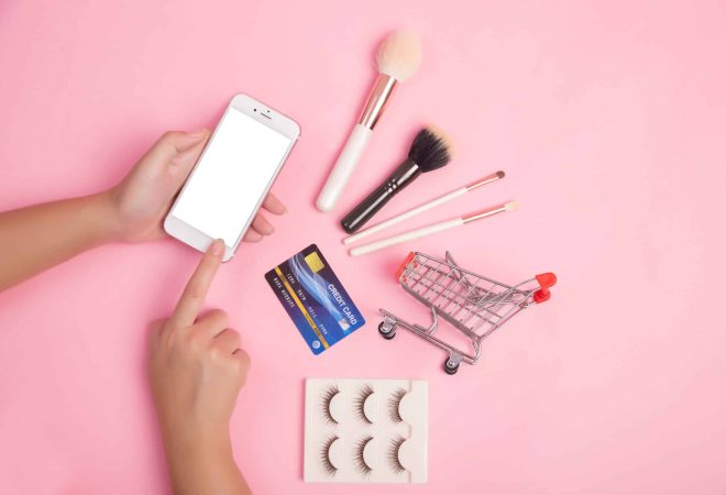 Woman using smartphone and credit card shopping beauty items